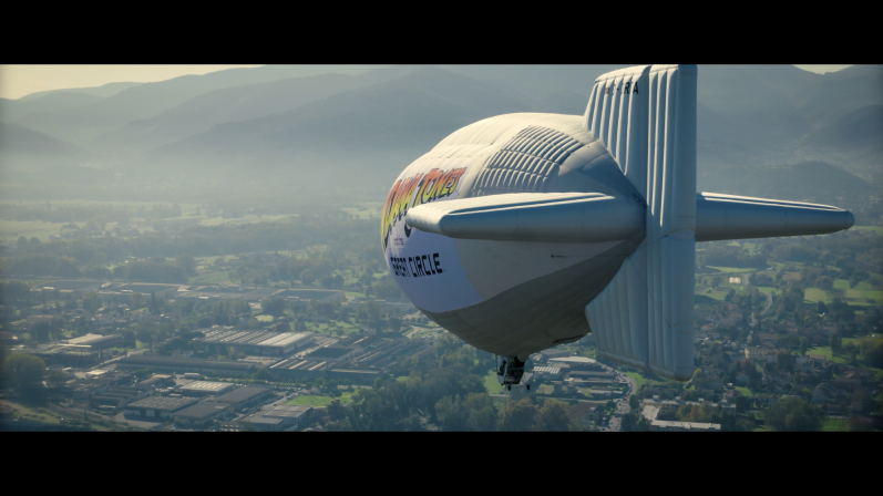 INDIANA JONES THE GREAT CIRCLE (2024) Luftschiff schwebt über einer Stadtlandschaft mit Bergen im Hintergrund.